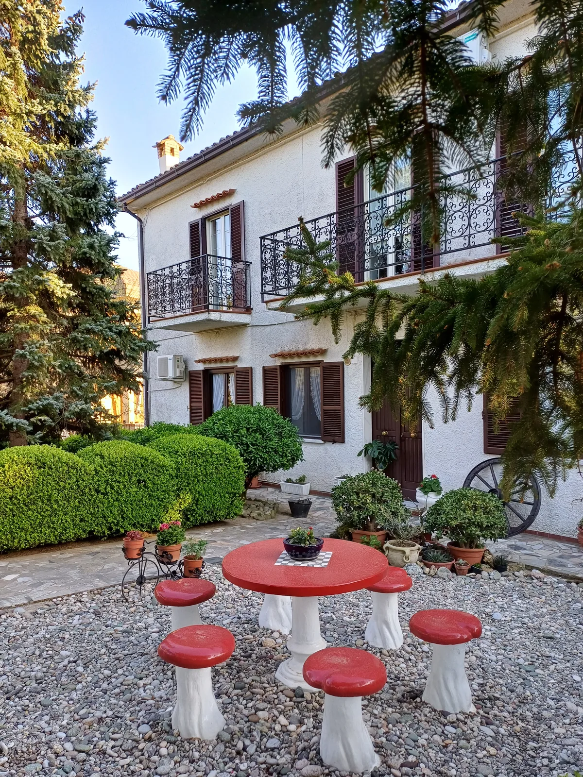 Giardino con tavolo-fungo e luce naturale tra il verde